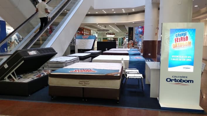 Imagem mostrando uma feira de camas e colchões, com vários produtos expostos
