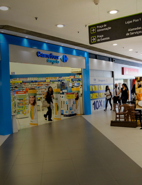 Imagem de um corredor de shopping, apresentando a entrada das lojas Carrefour em cor azul